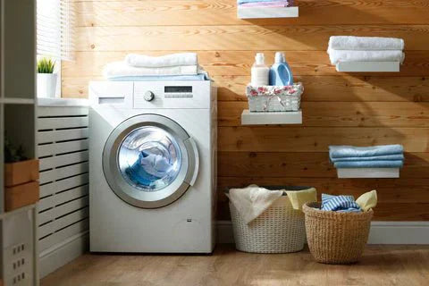 
      Washing machine in laundry room with laundry baskets and cleaning products on shelves
    
