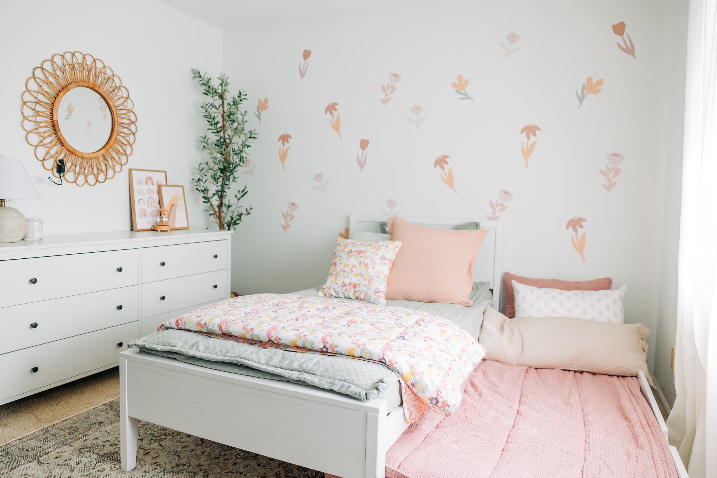 
      a girls room with a trundle bed, the trundle bed pulled out and both beds made with zipper bedding.
    