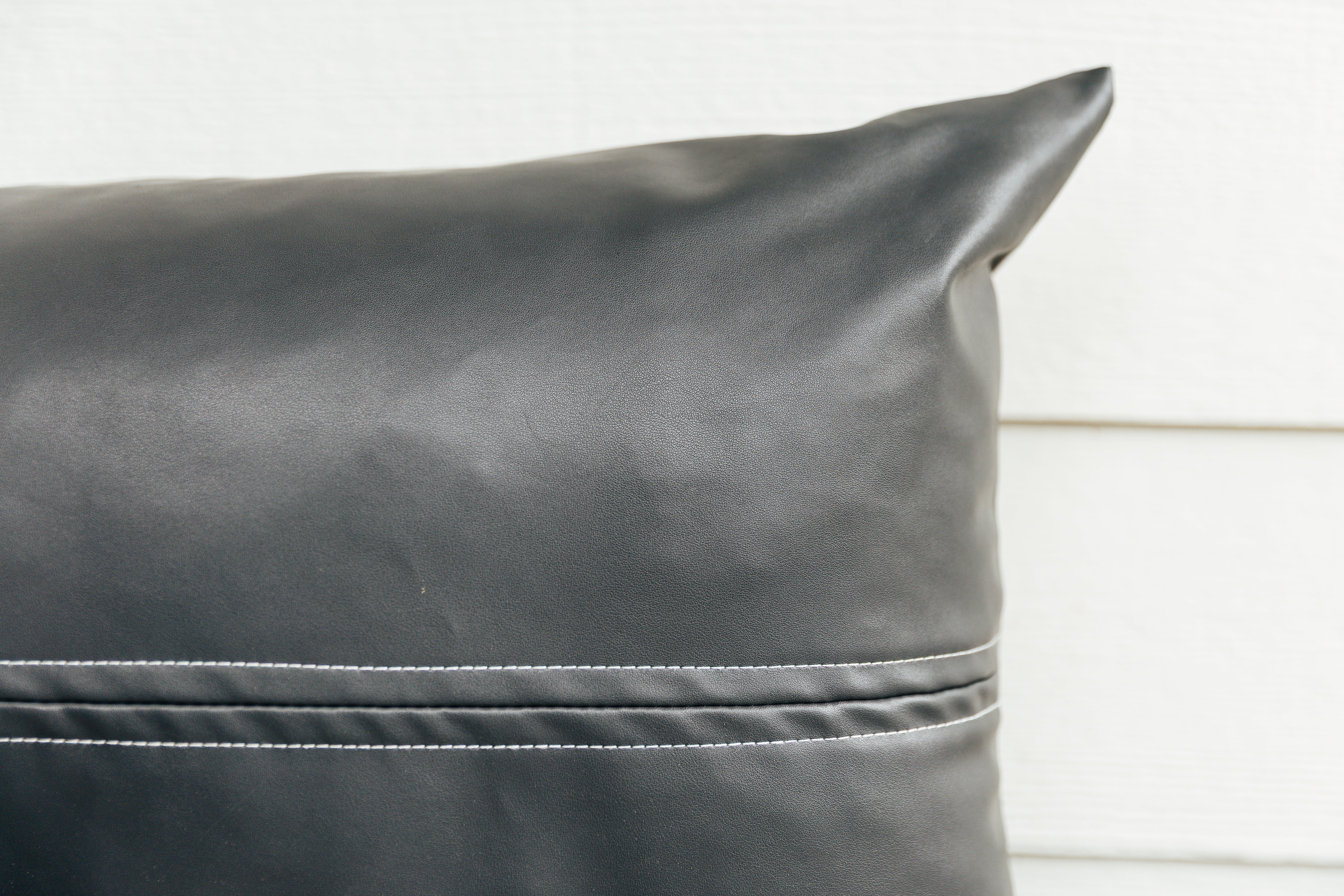 A close up on the exterior look and detailing of a charcoal lumbar pillow.